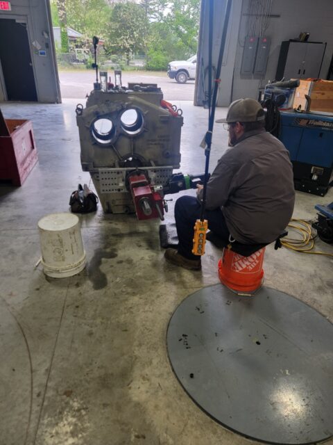 machinist operating portable boring equipment on gearbox