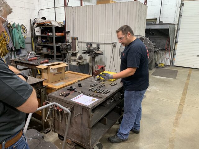 Man in navy blue shirt at a table with Mactech tools laid out for inventory.